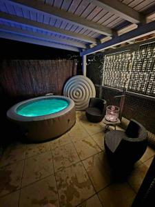 a bathroom with a jacuzzi tub and two chairs at Appartement calme avec jardin in Conthey