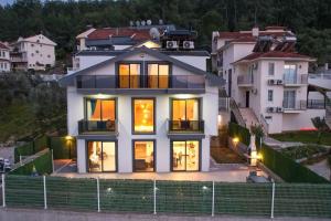 a large white house with its lights on at Villa Simge 4+1 Ölüdeniz in Fethiye