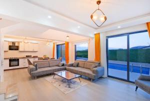 a living room with two couches and a table at Villa Simge 4+1 Ölüdeniz in Fethiye