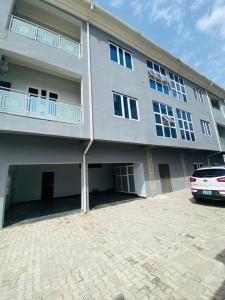 a large building with a car parked in front of it at Spacious two bedroom@City center in Kadobunkuro