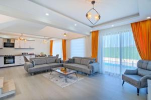 a living room with two couches and a table at Villa Simge 4+1 Ölüdeniz in Fethiye