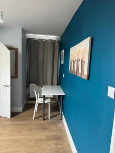 a dining room with a table and a blue wall at Nice and Pleasant in Thornton Heath +87 photos