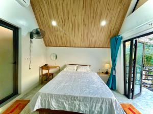 - une chambre avec un lit et un plafond en bois dans l'établissement Little Rock Homestay, à Phong Nha