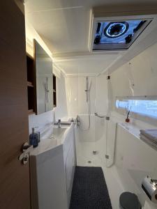 een badkamer met een bad, een wastafel en een douche bij La Rochelle sur L'eau - Catamaran in La Rochelle