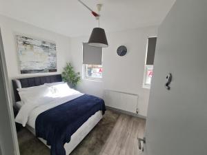 a bedroom with a bed with a blue blanket at Stratford Prime Rooms in London