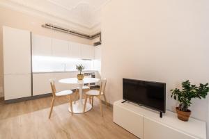 ein Wohnzimmer mit einem Tisch und einem TV in der Unterkunft Centro città - Comodo per visitare la città in Turin