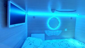 a room with a bed with a blue light at Happy Hotel in Rīga