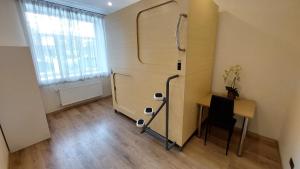 a small room with a desk and a refrigerator at Happy Hotel in Riga