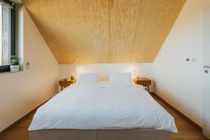 a bedroom with a large bed with a wooden ceiling at Plener Istebna in Istebna