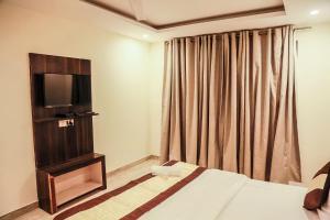 a hotel room with a bed and a television at Hotel Global Stay Near Delhi Airport in New Delhi