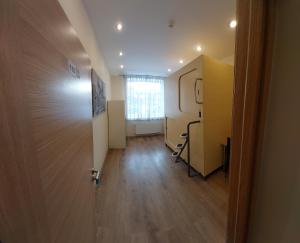 um quarto com um corredor com uma porta e uma janela em Happy Hotel em Riga