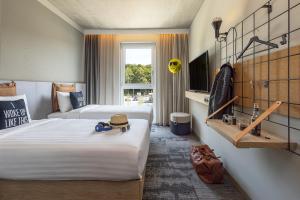 ein Hotelzimmer mit 2 Betten und einem TV in der Unterkunft Moxy Simmern in Simmern