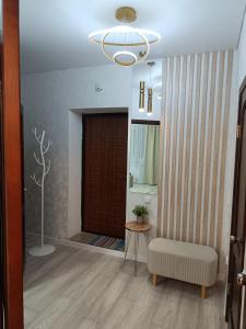 a hallway with a chair and a brown door at 1-комнатная квартира мкр. Аэропорт in Kostanay