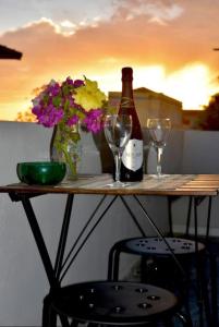 einen Tisch mit einer Flasche Wein und zwei Gläsern in der Unterkunft Casa vacanze La stella marina in SantʼAnna Arresi