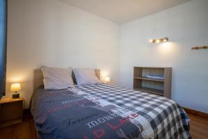 een slaapkamer met een bed met een blauwe en witte deken bij Grand Chalet St-Lary centre 13 à 15 pers in Saint-Lary-Soulan