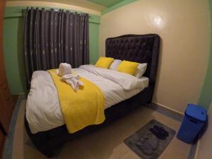 a bedroom with a bed with a yellow blanket at Nyeri Nest Retreat - One Bedroom in Nyeri