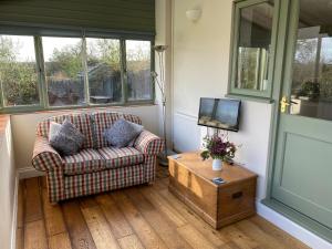 a living room with a couch and a tv at The Granary in Lydney