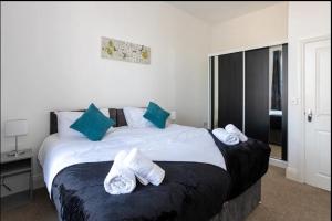 een slaapkamer met een groot bed en handdoeken bij Devonshire Road - Apartment 1 in Birkenhead