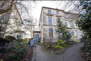 a large stone house with a driveway in front of it at Devonshire Road - Apartment 1 in Birkenhead