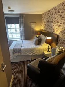 een hotelkamer met een bed en een bank bij The Cricketers Arms in Barnard Castle