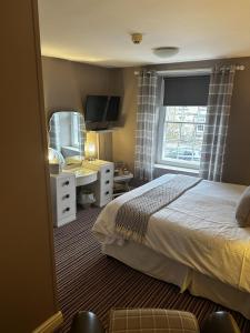 a bedroom with a bed and a sink and a mirror at The Cricketers Arms in Barnard Castle