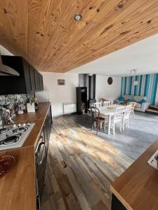 eine Küche und ein Wohnzimmer mit einem Tisch und Stühlen in der Unterkunft Jolie maison de campagne, Compostelle in Soleymieux