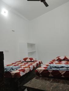 duas camas sentadas uma ao lado da outra num quarto em Ram Tilak homestay em Faizābād