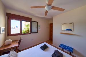 a bedroom with two beds and a ceiling fan at Rhea in San José