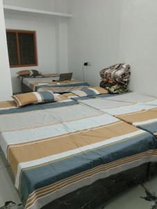 um grupo de camas alinhadas num quarto em Ram Tilak homestay em Faizābād