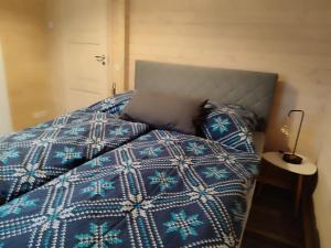 Una cama con edredón azul y almohadas. en Blockhaus Barbarossa Annie, en Rottleben