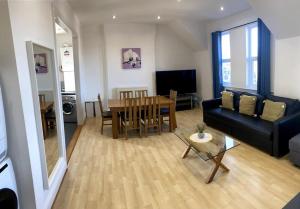a living room with a black couch and a table at Huge Flat Sleeps 6+ free parking in Nottingham
