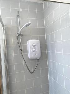 a shower with a shower head in a bathroom at Huge Flat Sleeps 6+ free parking in Nottingham