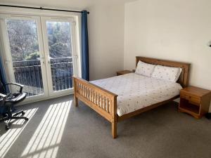 a bedroom with a bed and a large window at Huge Flat Sleeps 6+ free parking in Nottingham