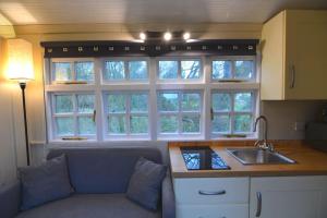 a kitchen with a couch and a sink and windows at Rectory Retreat in Norwich