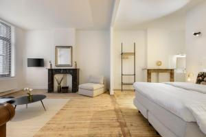 a white bedroom with a bed and a fireplace at The 1894 Residence by Domani Hotels in Antwerp