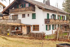 Cette maison ancienne dispose de volets verts et d'un balcon. dans l'établissement Haus Alpenquelle Seeblick, à Bad Kohlgrub