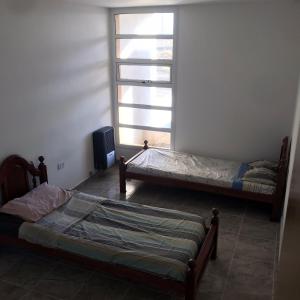 Casa de Playa في بلاليا أونيون: سريرين في غرفة مع نافذة