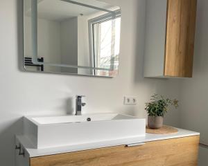 uma casa de banho com um lavatório branco e um espelho. em Ferienwohnung Delta em Heinsberg
