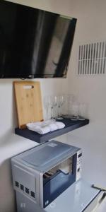 a microwave sitting on a counter with glasses on it at Relaxing Room With Ensuite Rutland Point in Oakham