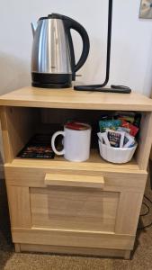 a wooden shelf with a tea pot and a coffee cup at Relaxing Room With Ensuite Rutland Point in Oakham