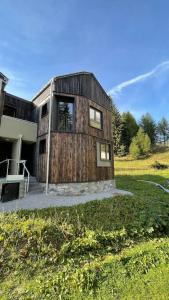 een houten huis bovenop een veld bij Chalet immerso nel verde in Madesimo