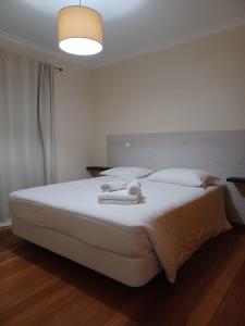 um quarto branco com uma cama grande e lençóis brancos em Ocean Paradise Til II no Funchal