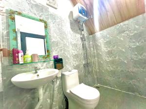 uma casa de banho com um WC branco e um lavatório. em Little Rock Homestay em Phong Nha