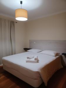 um quarto com uma grande cama branca com toalhas em Ocean Paradise Til II no Funchal