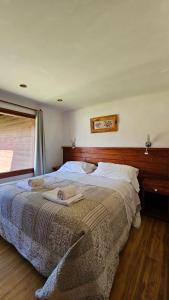 una camera da letto con un letto e due asciugamani di Complejo Raíces Patagonicas a Dina Huapi