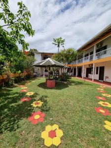 a yard with flowers on the grass in front of a building at Pousada Recanto Aconchego in Itapoa +2 photos