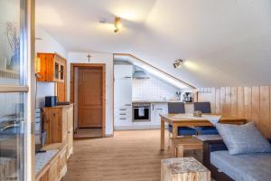 cocina y sala de estar con sofá y mesa en Haus Alpenquelle Seeblick, en Bad Kohlgrub