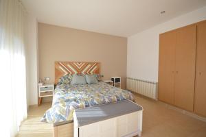 um quarto com uma cama grande e uma cabeceira em madeira em Villa Naira em Calonge