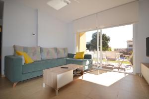 uma sala de estar com um sofá azul e uma mesa em Villa Naira em Calonge