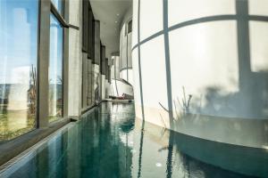 a building with a pool of water in front of it at Seerose Resort & Spa in Meisterschwanden